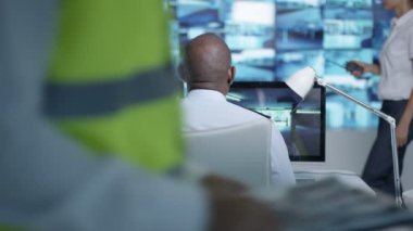 4k güvenlik takım izlemek Cctv ekranları kontrol odasında, memur radyoda konuşma