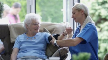 Bakım hemşire Huzurevi yaşlı bayanın kan basıncı kontrol.