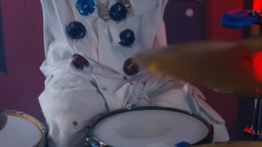 4k Davul setine yakın, bir grupta oynayan astronot gibi giyinmiş davulcu