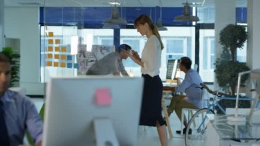 Arka planda bir toplantıda meslektaşları ile masada gülümseyen Tasarımcısı portresi