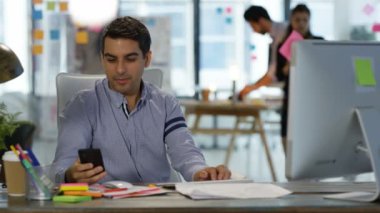 arka planda çalışma arkadaşları ile masasında cep telefonuyla konuşurken mayite iş adamı.