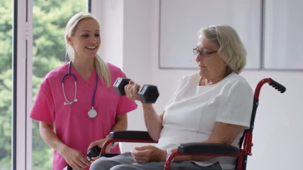 Krankenschwester Altenheim Zeigt Älteren Dame Rollstuhl Einige Übungen Mit Gewichten — Stockvideo