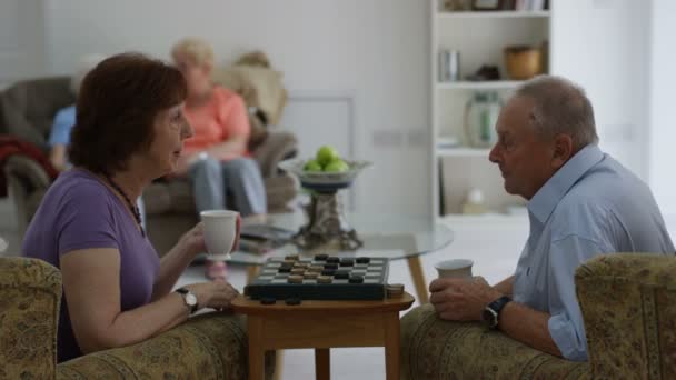 Senior Man Vrouw Spelen Van Dammen Een Pensioen Huis Jonge — Stockvideo