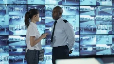 4k güvenlik takım izlemek Cctv ekranları kontrol odasında, memur radyoda konuşma