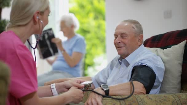 Junge Krankenschwester Überprüft Pflegeheim Den Blutdruck Eines Älteren Mannes — Stockvideo