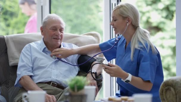 Junge Krankenschwester Überprüft Pflegeheim Den Blutdruck Eines Älteren Mannes — Stockvideo