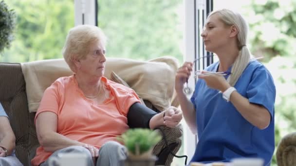 Pflegende Krankenschwester Überprüft Pflegeheim Den Blutdruck Einer Älteren Dame — Stockvideo