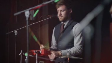 müzik grubu gece kulübünde sahnede, bateri ve gitar oynayan adam şarkı performans 