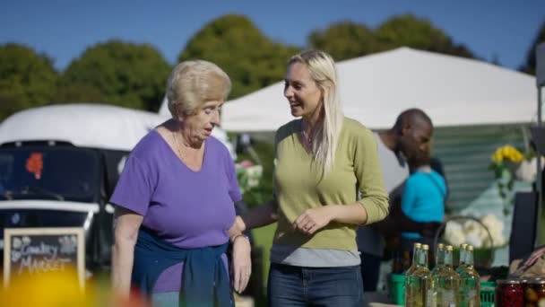 Jonge Vrouw Met Senior Dame Browsen Kraampjes Boerenmarkt — Stockvideo