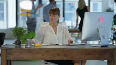 Beyaz işkadını tartışma içinde geçmiş meslektaşları ile modern ofis masasında, cep telefonuyla konuşurken.