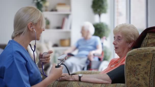 Jonge Verpleegster Bloeddruk Controle Bejaarde Dame Verpleeghuis — Stockvideo