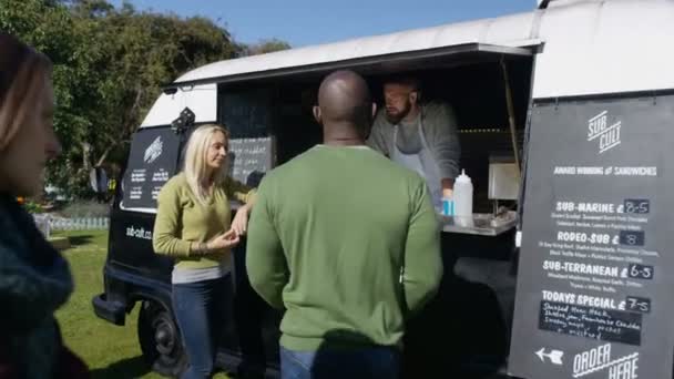 4k Cheerful Food Vendor In Burger Van Serving Customers At Community Event
