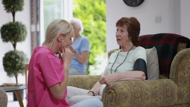 Junge Krankenschwester Überprüft Pflegeheim Den Blutdruck Einer Älteren Dame — Stockvideo