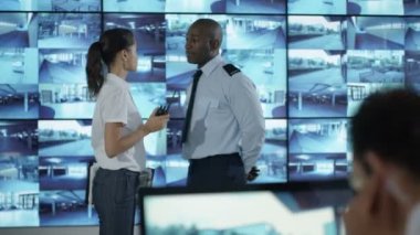 4k güvenlik takım izlemek Cctv ekranları kontrol odasında, memur radyoda konuşma