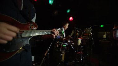 şarkı gece kulübü sahne alanı'nda, akustik gitar, davul ve mandolin çalmaya erkekler müzikal bant