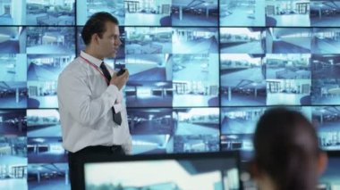 4k güvenlik takım izlemek Cctv ekranları kontrol odasında, memur radyoda konuşma