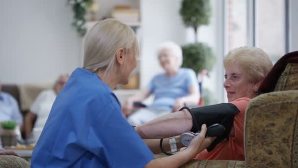 Enfermera Joven Revisando Presión Arterial Una Anciana Hogar Ancianos — Vídeos de Stock