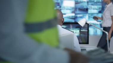 4k güvenlik takım izlemek Cctv ekranları kontrol odasında, memur radyoda konuşma