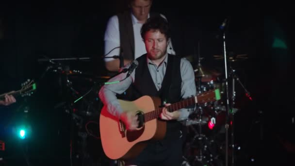 アコースティック ギターとドラムを演奏する男性ナイトクラブのステージで歌を行う音楽バンド — ストック動画