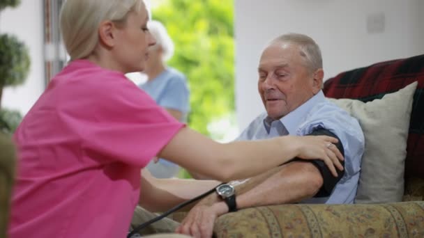 Jonge Verpleegster Bloeddruk Controle Bejaarde Man Verpleeghuis — Stockvideo