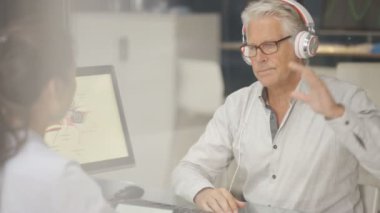bir işitme testi Odyoloji doktor ile Başlarken 4 k olgun adam giyen kulaklık,.