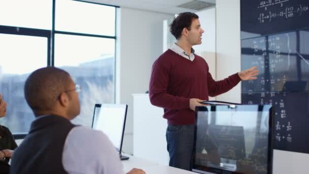 4K Étudiants travaillant sur ordinateur et écoutant un enseignant dans une classe d'éducation des adultes 