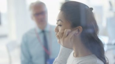 4k sağırlık işitme onun kulak içine koyarak ve doktor ile tartışırken kadınla