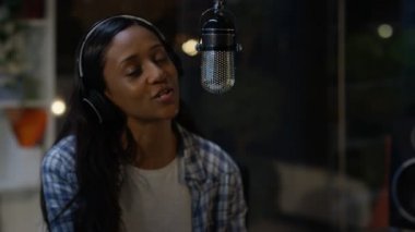 kadının mikrofon kayıt stüdyosunda otururken şarkı 