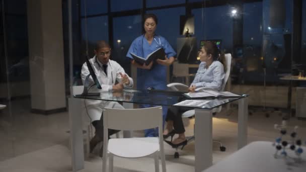 Equipo Médico Turno Noche Teniendo Una Reunión Mirando Escaneos Pacientes — Vídeo de stock