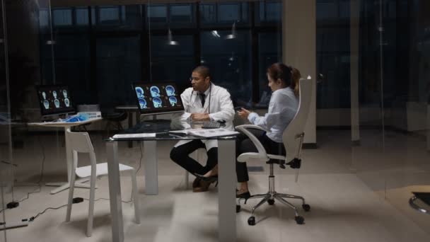 Personnel médical 4K de nuit ayant une réunion, regardant les scans des patients 