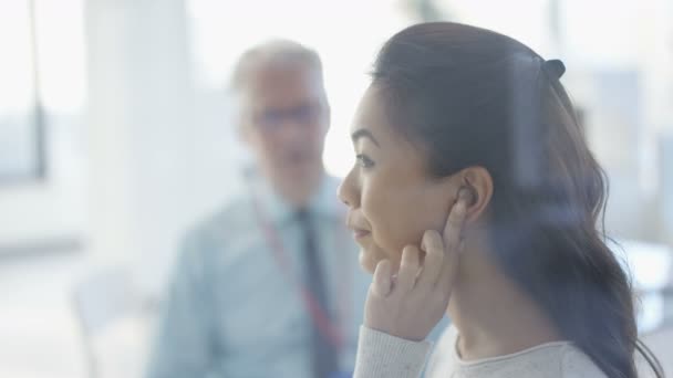 難聴であることと女性のために合うこんにちはテック補聴器医師保持ミラー — ストック動画