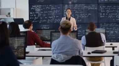4k öğrencilerine Matematik formüller açıklayan yetişkin eğitim sınıf öğretmeni