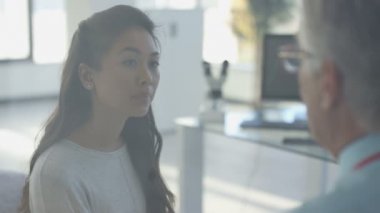 4 k Odyoloji doktor için işitme cihazı monte ediliyor bayan hasta ile