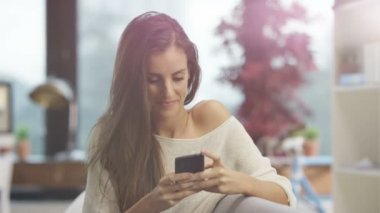 4k evde rahatlatıcı, smartphone vasıl seyir çekici gülümseyen kadın portresi