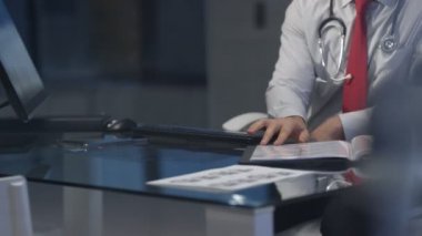 4k tıbbi notları okuyor ve bilgisayarda çalışan modern hastanede doktor