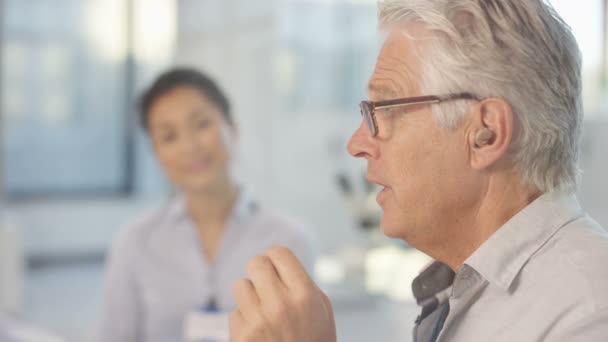 Hombre Con Sordera Poniendo Audífono Oído Médico Mostrando Diagrama — Vídeos de Stock