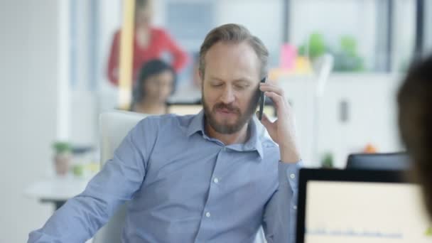 Affärsman Sitter Vid Sitt Skrivbord Och Tar Mobilen — Stockvideo