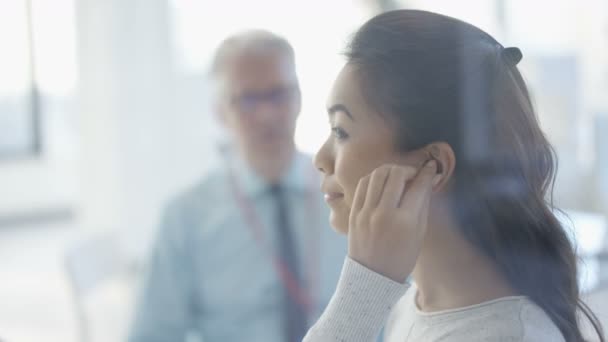 Frau Mit Gehörlosigkeit Wird Für Tech Hörgeräte Ausgestattet Arzt Hält — Stockvideo