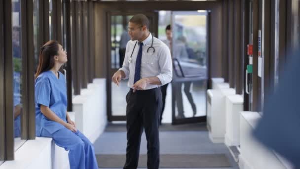 Médico Enfermera Varones Teniendo Una Discusión Ocupado Pasillo Del Hospital — Vídeo de stock