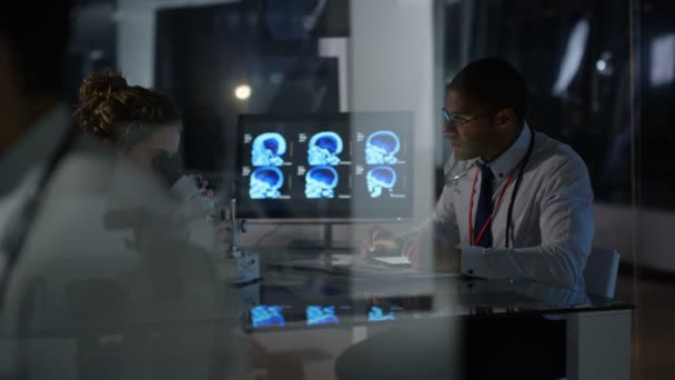 医疗研究小组使用电脑上夜班 关注男医生 — 图库视频影像