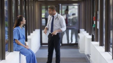 4 k erkek doktor ve hemşire meşgul hastane koridorunda bir tartışma sahip