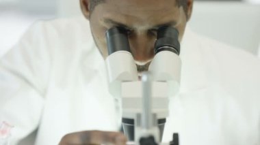 mikroskop bakarak laboratuarında çalışan tıbbi araştırmacı, 4k yakın çekim