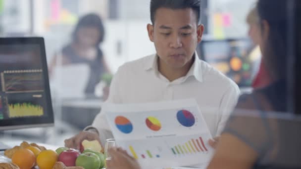 4K Équipe d'affaires dans une réunion avec de la nourriture et des rafraîchissements dans le bureau 