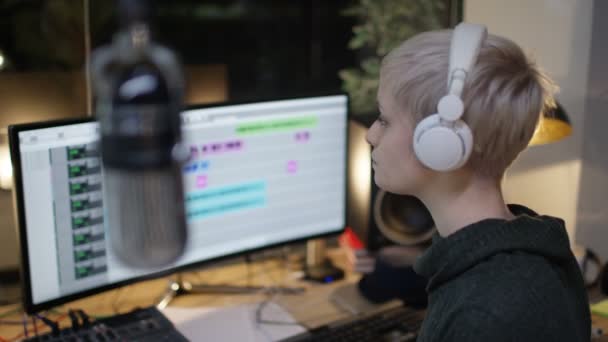 金髪の若い女性の記録歌 ミキシング ソフトウェアのマイクで歌うコンピューターと作業 — ストック動画