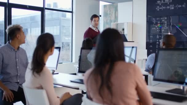 4K Étudiants travaillant sur ordinateur et écoutant un enseignant dans une classe d'éducation des adultes 