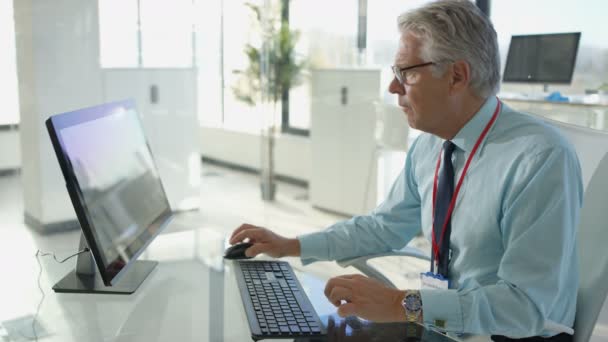 Medico Specialista Alla Sua Scrivania Guardando Apparecchio Acustico Digitando Rapporto — Video Stock