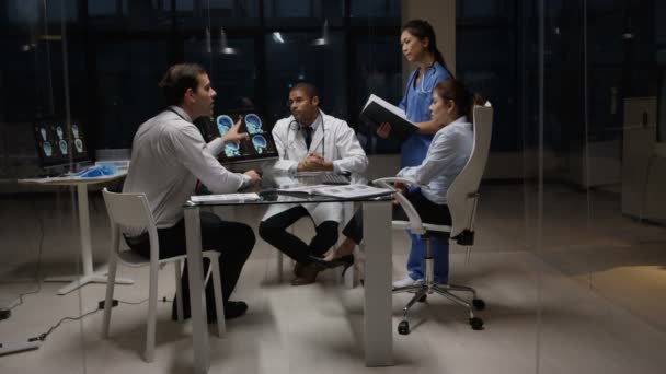 Equipo Médico Turno Noche Teniendo Una Reunión Mirando Escaneos Pacientes — Vídeo de stock