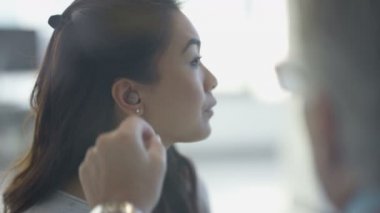 4k sağırlık işitme onun kulak içine koyarak ve doktor ile tartışırken kadınla
