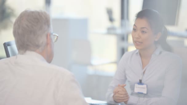 Audiologi Läkare Visar Patienten Modern Tech Hörapparat Och Förklara — Stockvideo