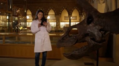 4k dinozor yanında duran ve bilgisayar tablet vasıl seyir Müzesi'nde bilim adamı